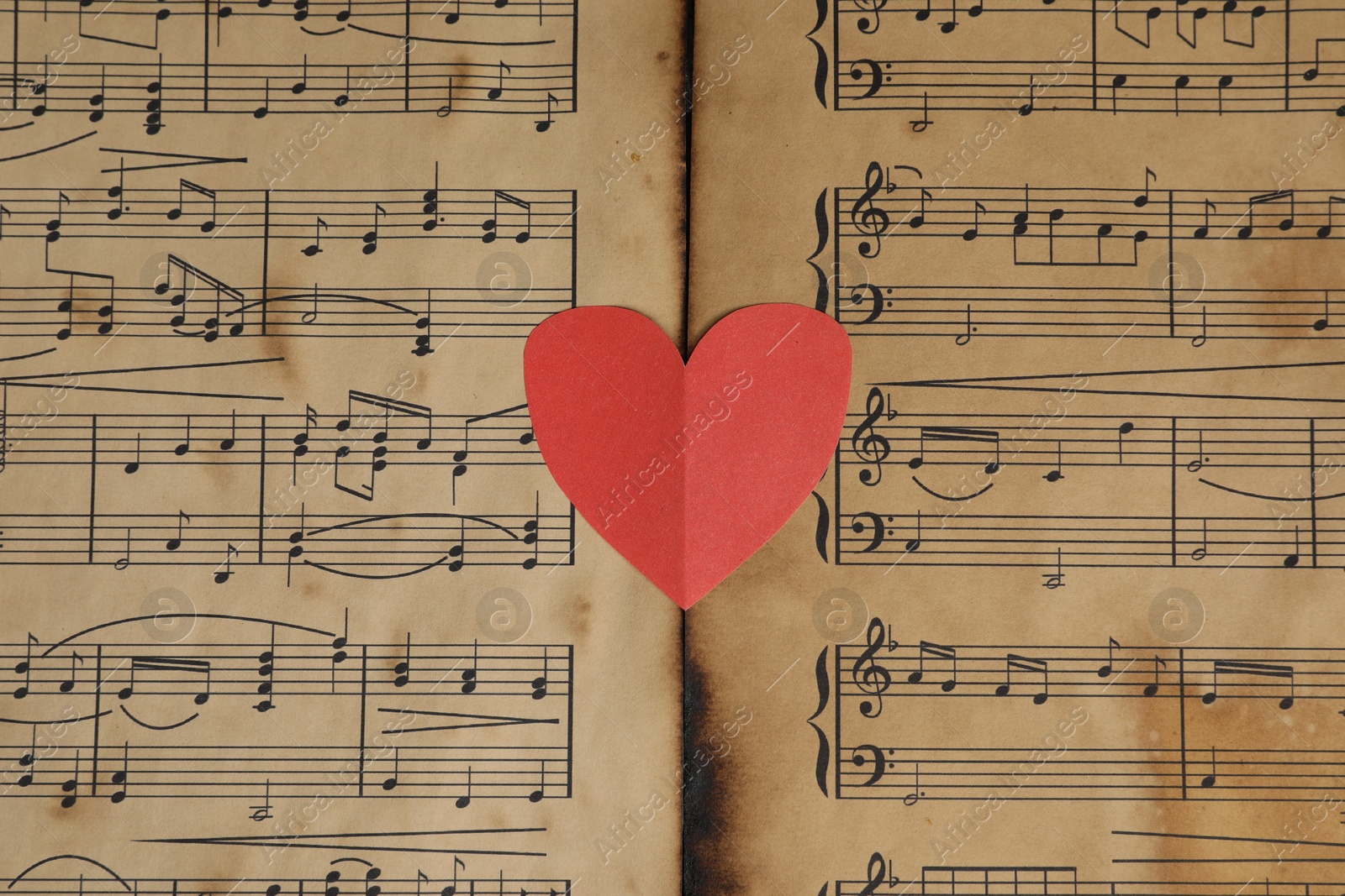 Photo of Paper heart on musical note sheets, top view