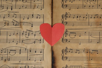 Photo of Paper heart on musical note sheets, top view