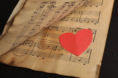 Photo of Paper heart and musical notes on black background, closeup