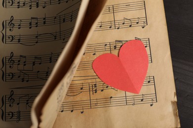 Photo of Paper heart and musical notes on black background, closeup