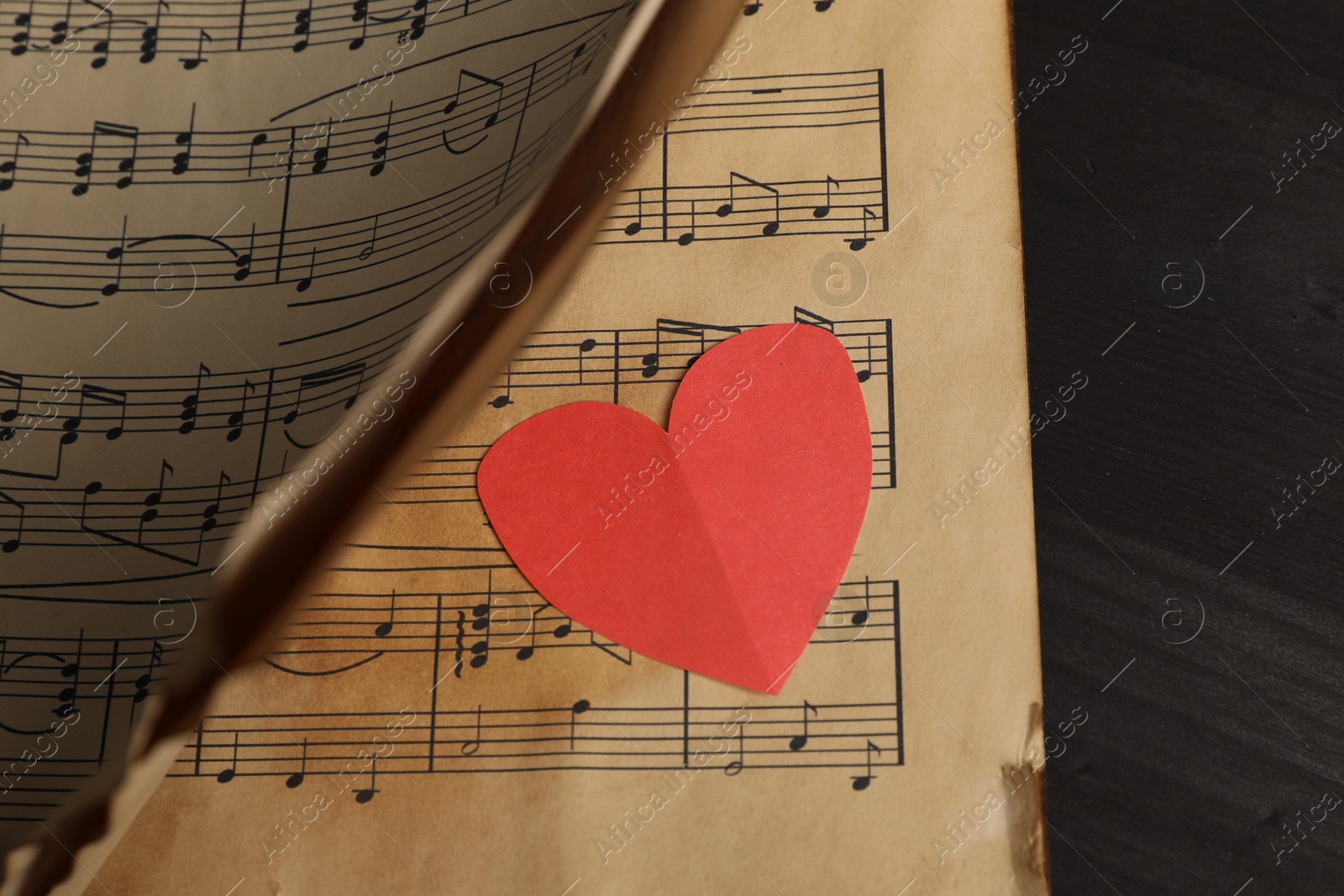 Photo of Paper heart and musical notes on black background, closeup