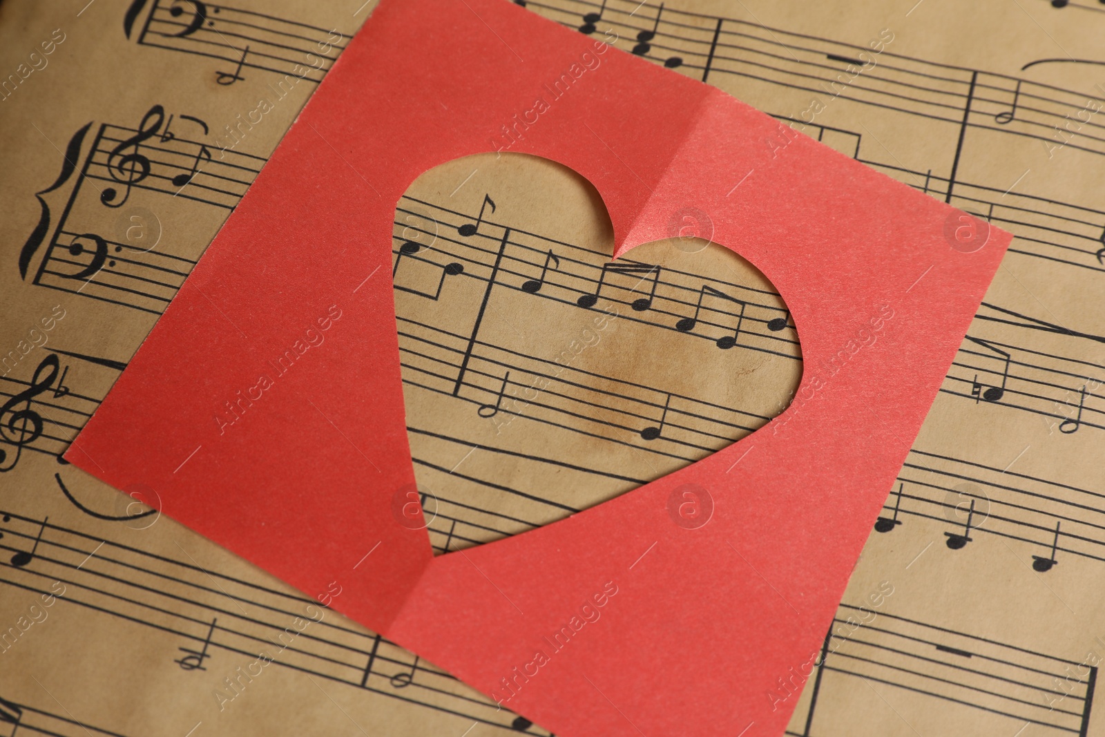 Photo of Heart shaped cutout on musical notes, closeup