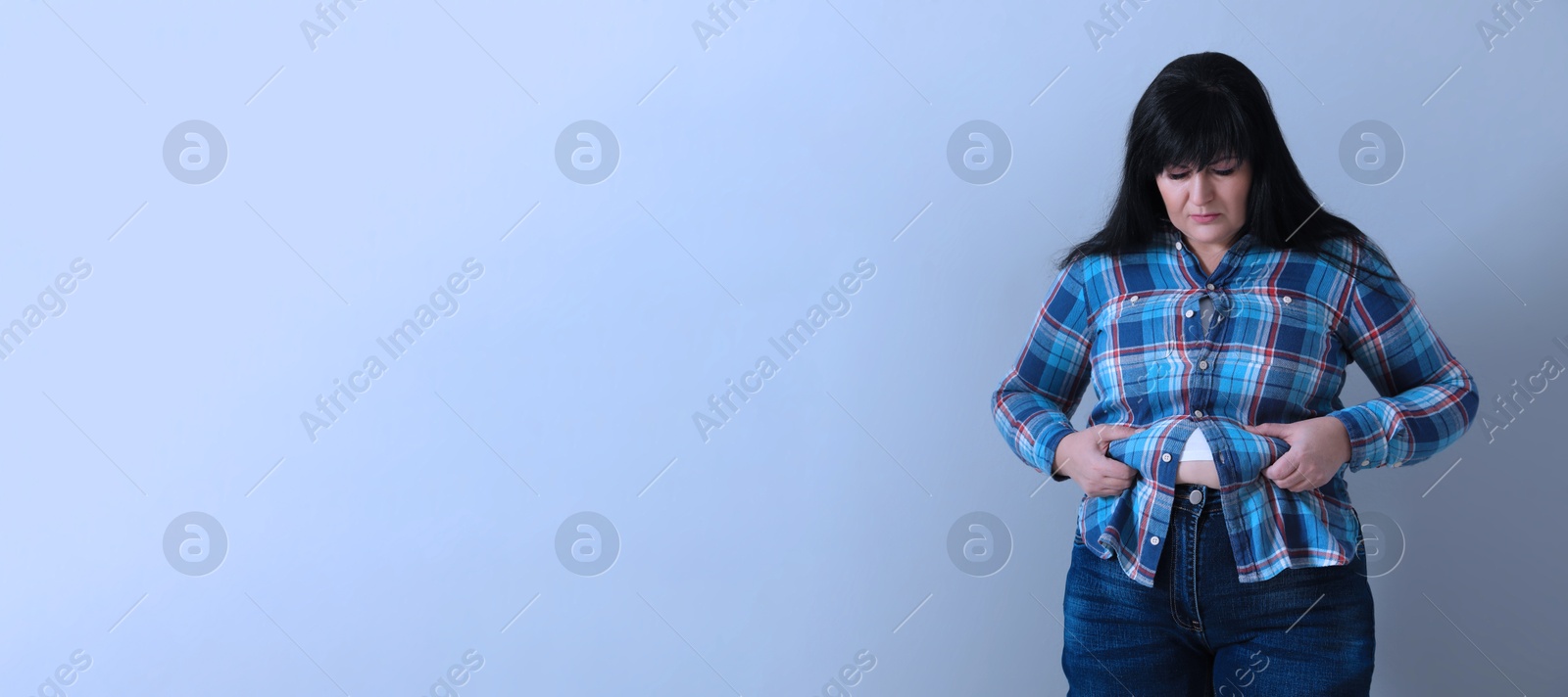 Image of Overweight woman in tight shirt on color background. Banner design with space for text