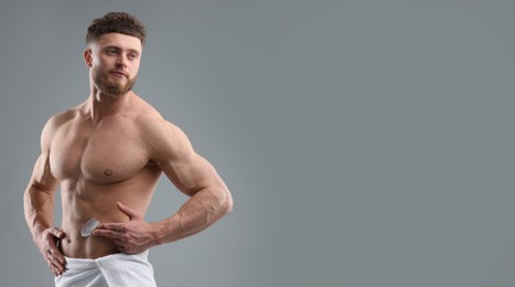 Image of Young man applying cream on skin against grey background. Banner design with space for text. Body care