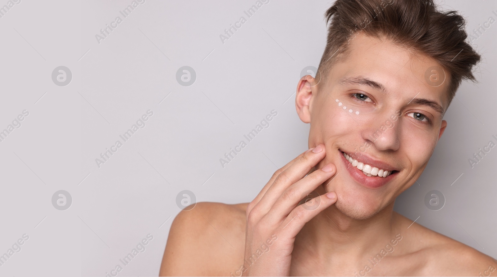 Image of Young man with cream on his face against light grey background. Banner design with space for text. Skin care