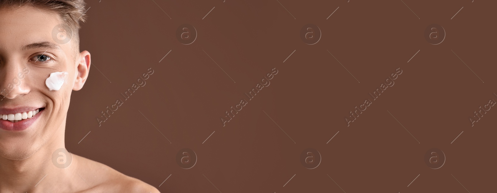 Image of Young man with cream on his face against brown background. Banner design with space for text. Skin care