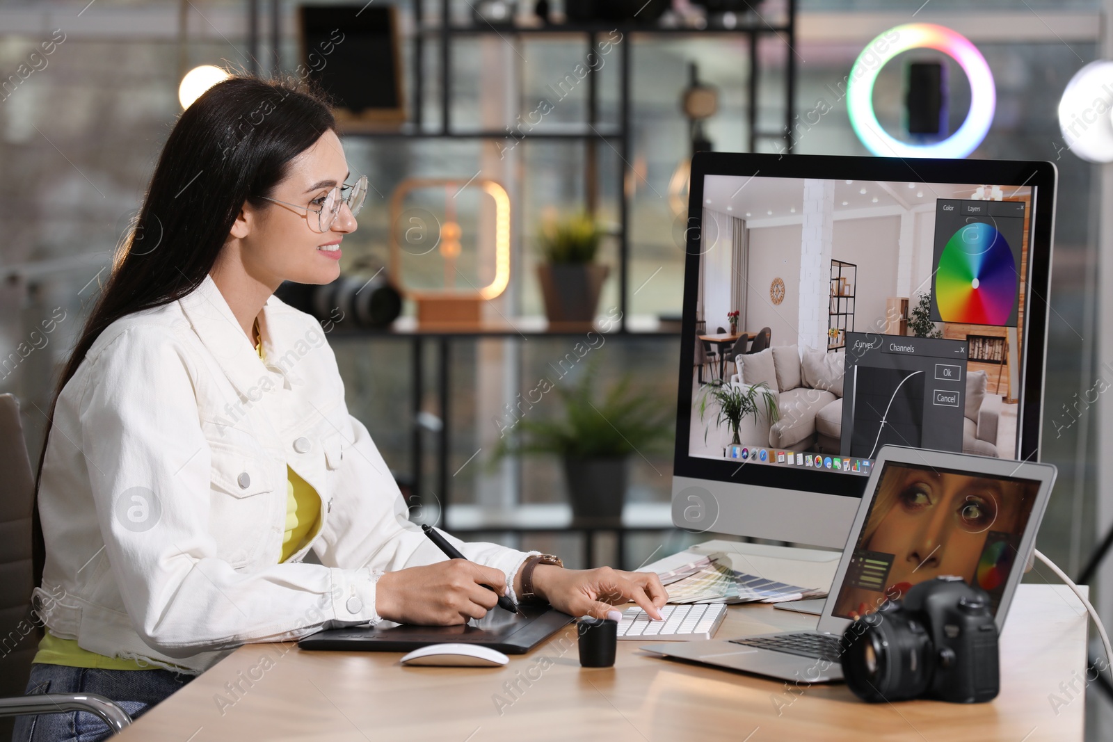 Photo of Professional retoucher working on computer and laptop in office