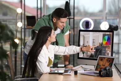 Photo of Professional retoucher with colleague at workplace in office