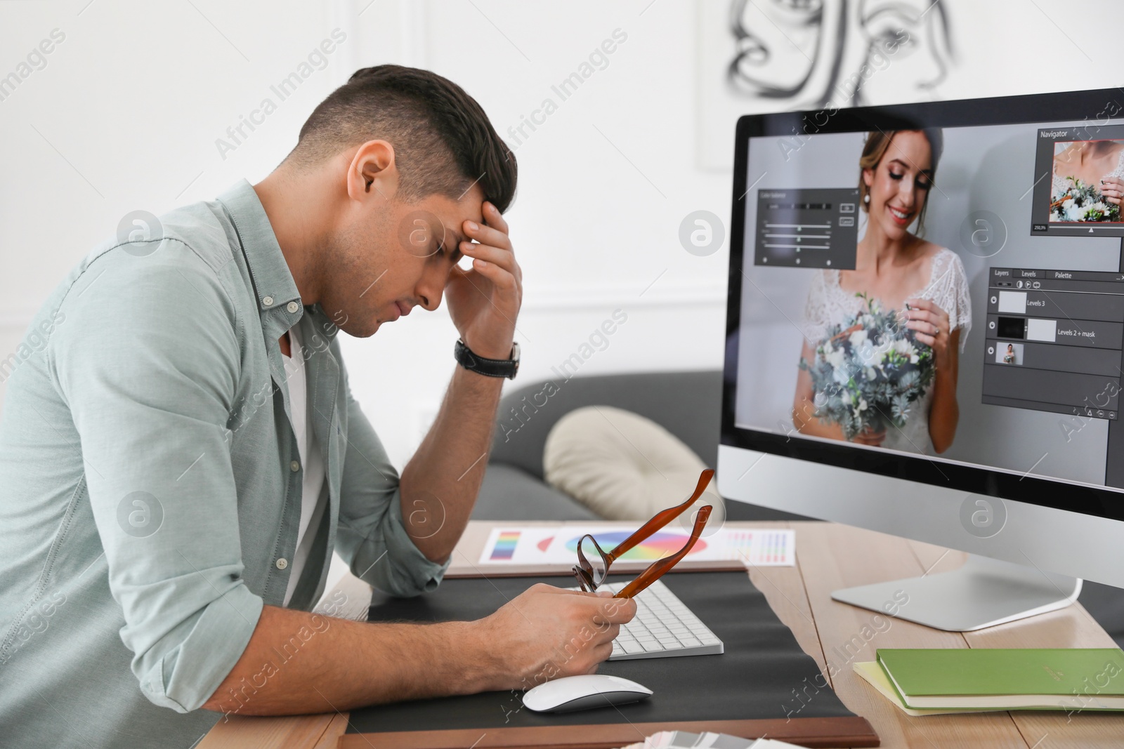 Photo of Tired retoucher at workplace with computer in office