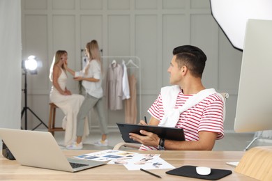 Photo of Professional retoucher working with graphic tablet at desk in photo studio