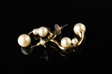 Photo of Beautiful bijouterie. Stylish earrings on black background