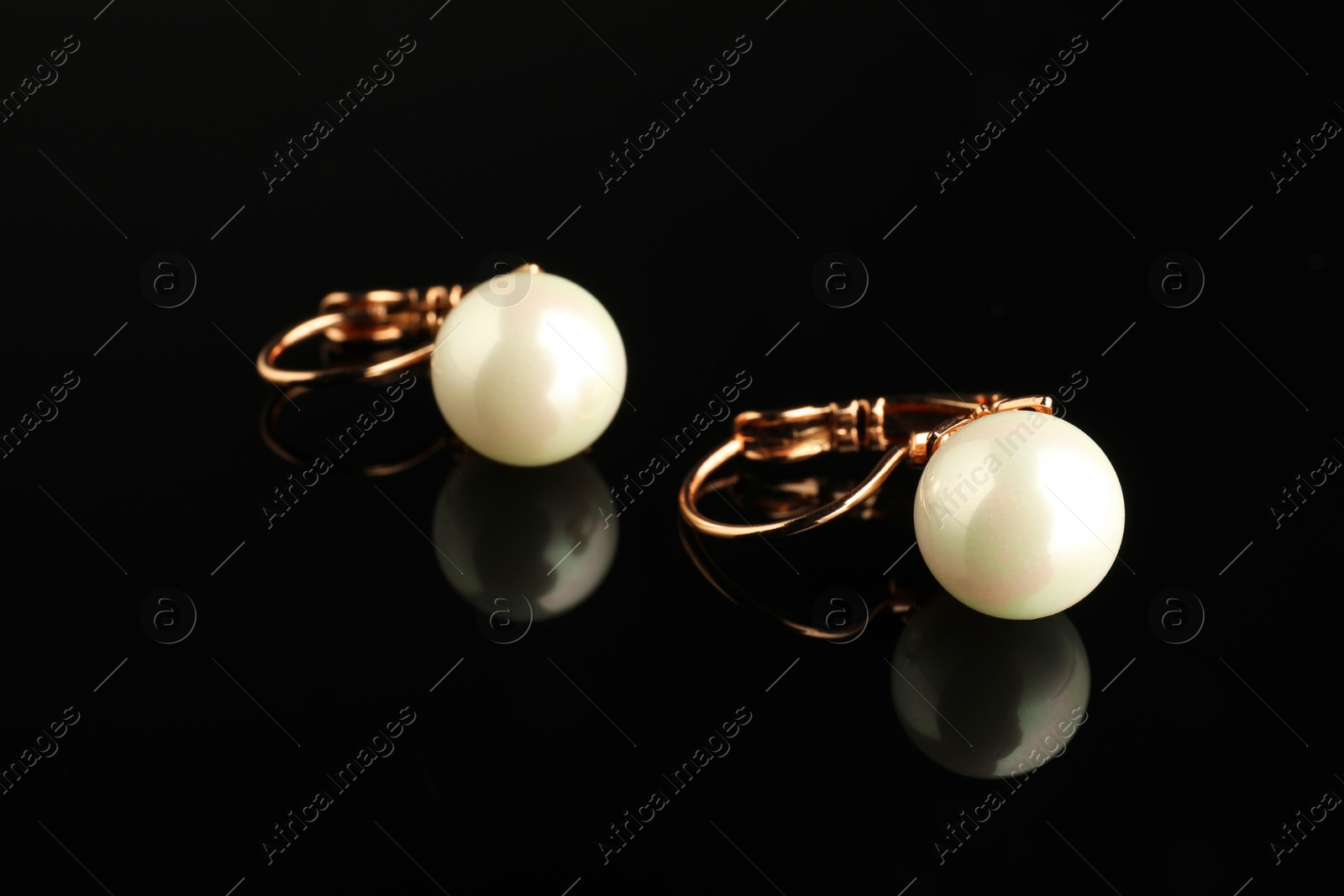 Photo of Beautiful bijouterie. Stylish earrings on black background