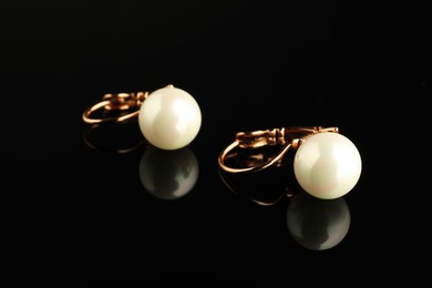 Photo of Beautiful bijouterie. Stylish earrings on black background