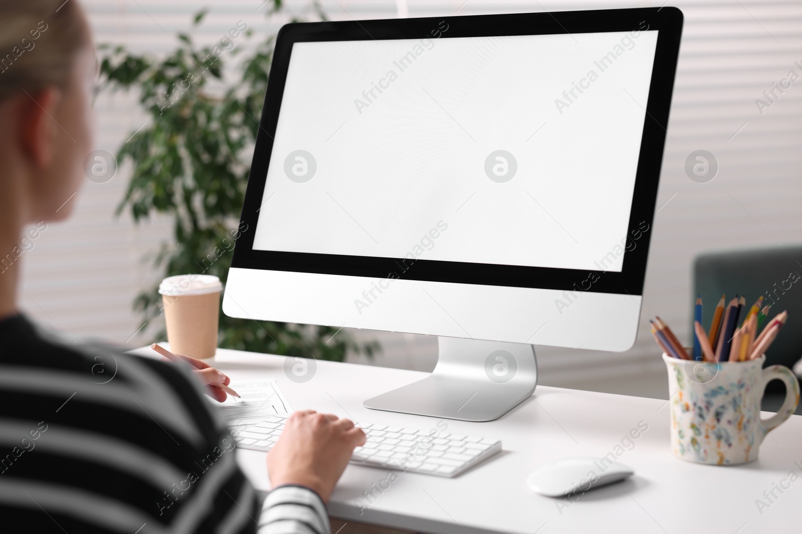 Photo of Woman working with computer monitor at table in office, closeup. Mockup for design