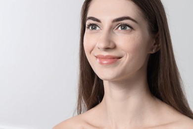 Photo of Beautiful young woman after henna eyebrows dyeing on light background