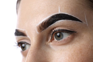 Photo of Young woman during henna eyebrows dyeing procedure on light background, closeup