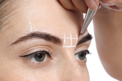 Young woman undergoing henna eyebrows dyeing procedure, closeup