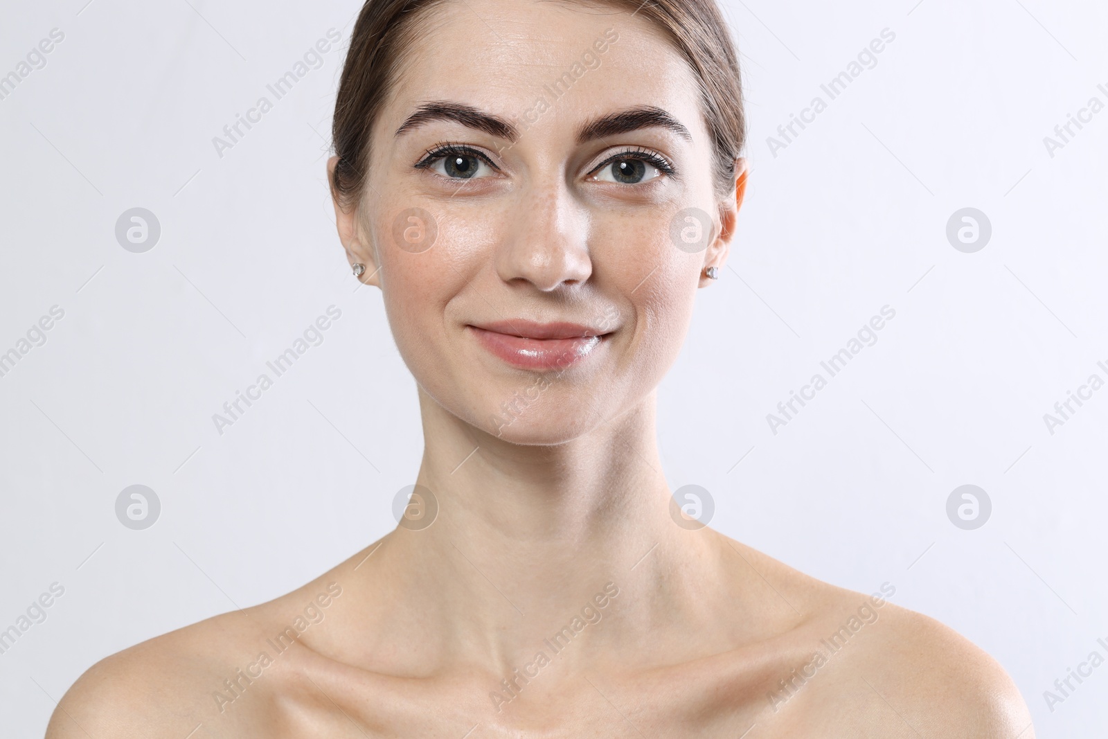 Photo of Beautiful young woman after henna eyebrows dyeing on light background, closeup