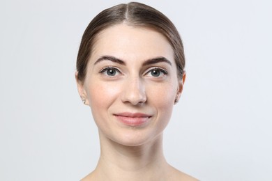 Photo of Beautiful young woman after henna eyebrows dyeing on light background, closeup