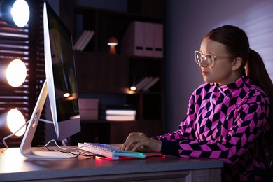 Photo of Girl playing video game with keyboard at table indoors