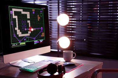 Computer keyboard, monitor, headphones and mouse on table indoors. Space for text