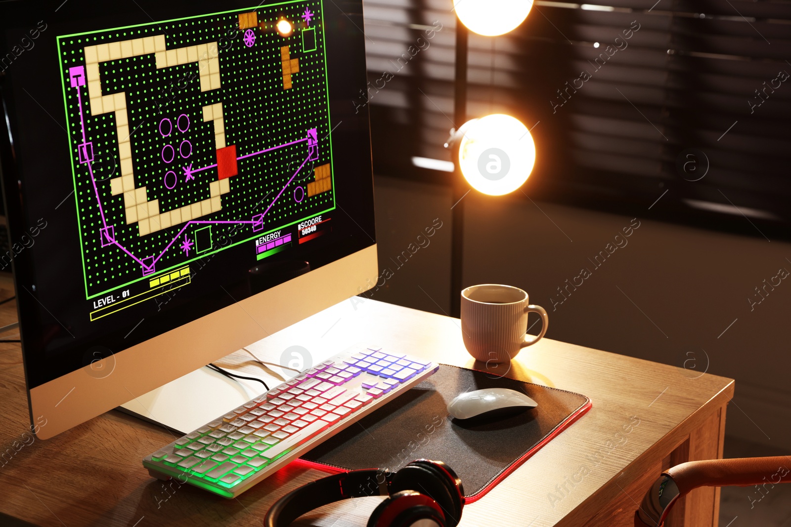 Photo of Computer keyboard, monitor, headphones and mouse on table indoors