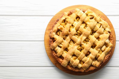 Photo of Tasty homemade apple pie on white wooden table, top view. Space for text