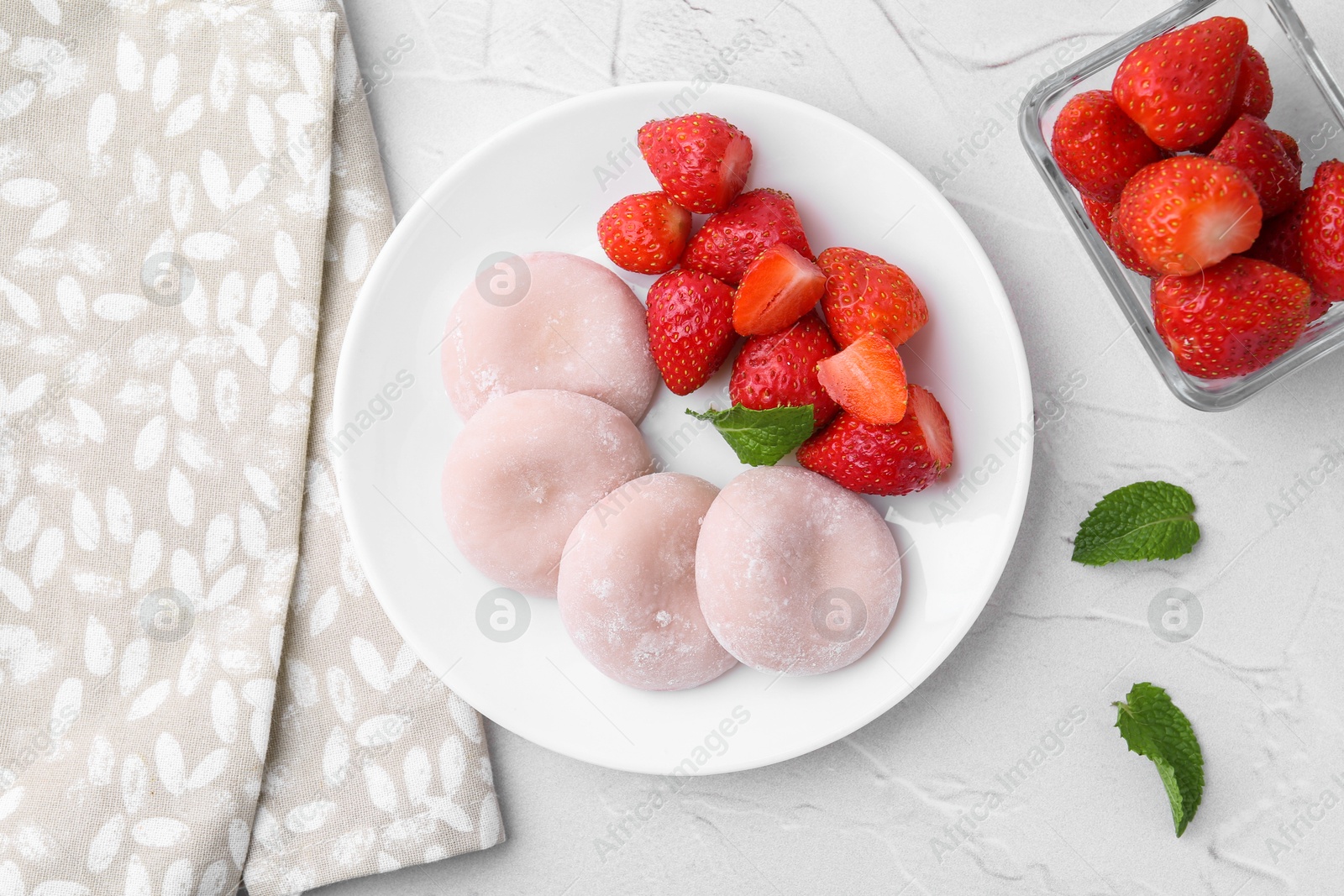 Photo of Delicious mochi and strawberries on white table, top view