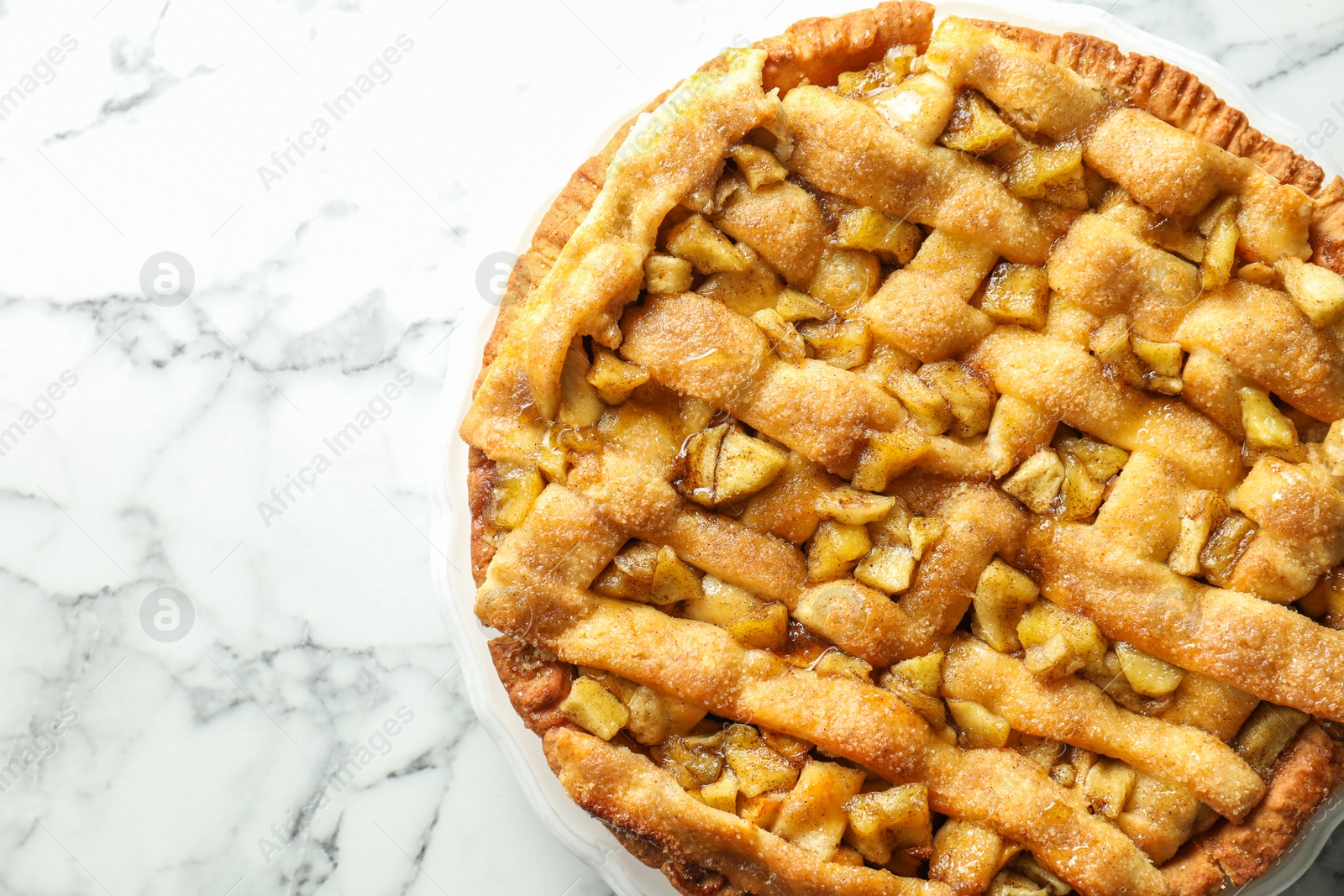 Photo of Homemade apple pie on white marble table, top view. Space for text