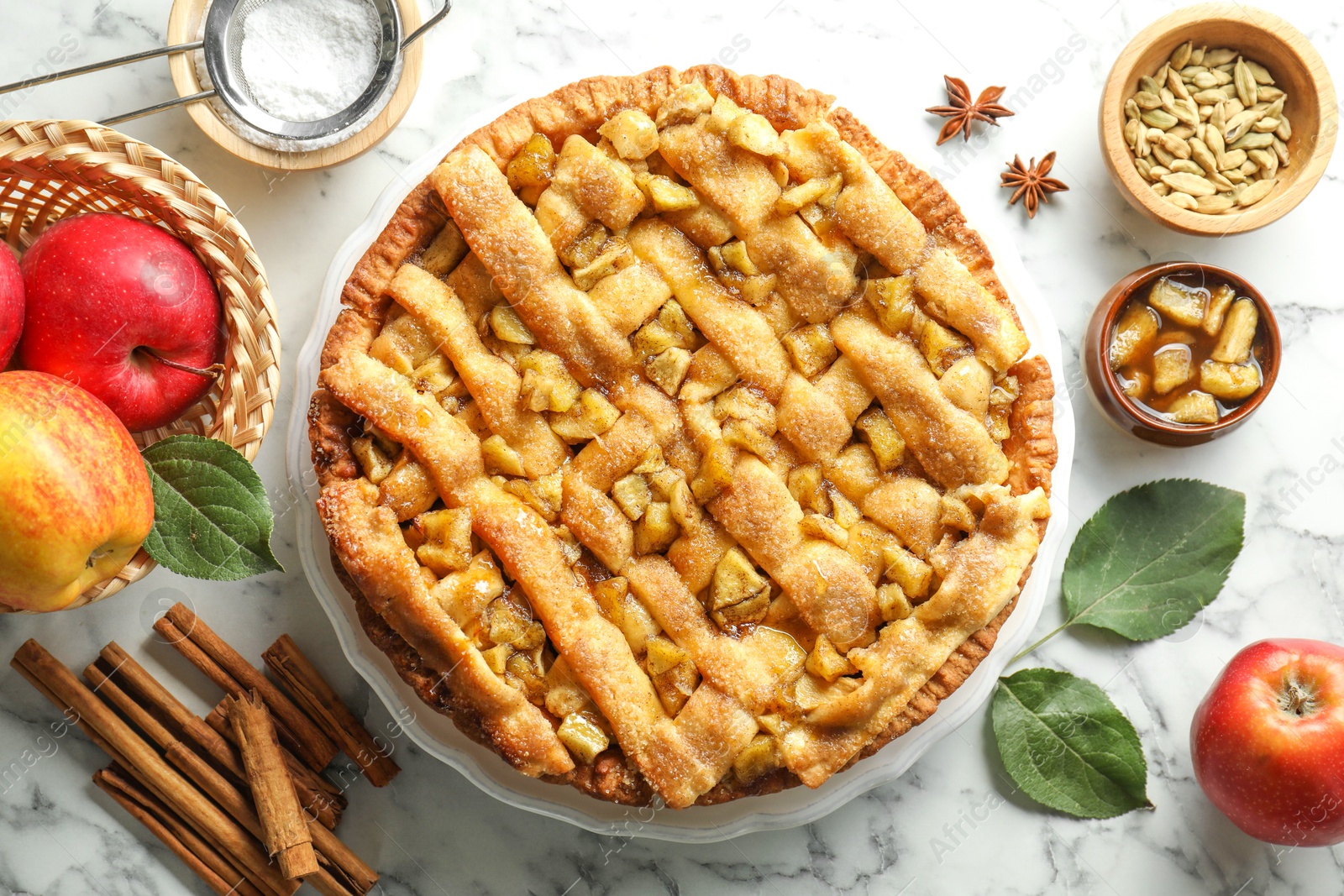 Photo of Homemade apple pie and ingredients on white marble table, flat lay