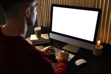 Man using computer monitor at table indoors