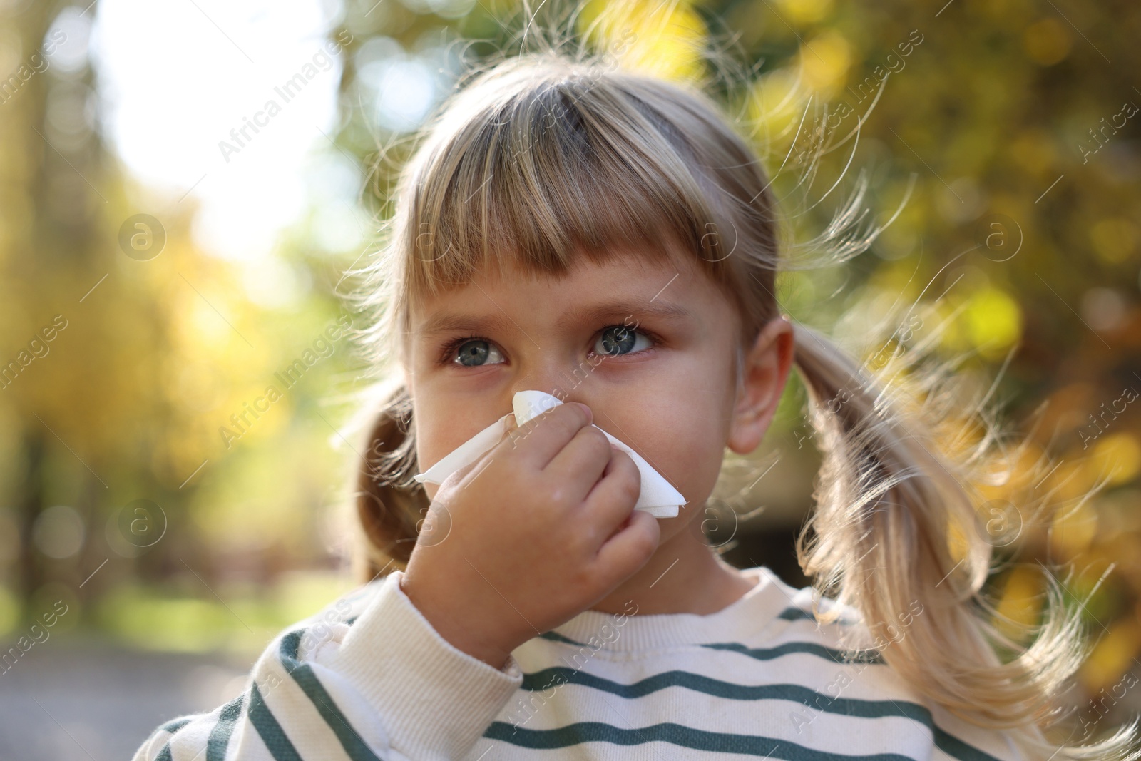 Photo of Little girl with runny nose in park