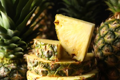 Slices of ripe pineapples on blurred background, closeup