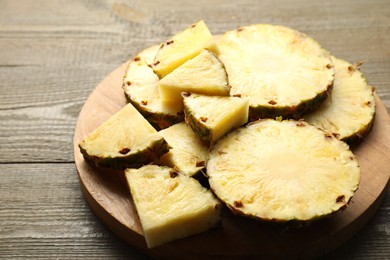 Slices of ripe pineapple on wooden table, closeup