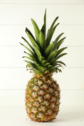 Photo of One fresh ripe pineapple on white table