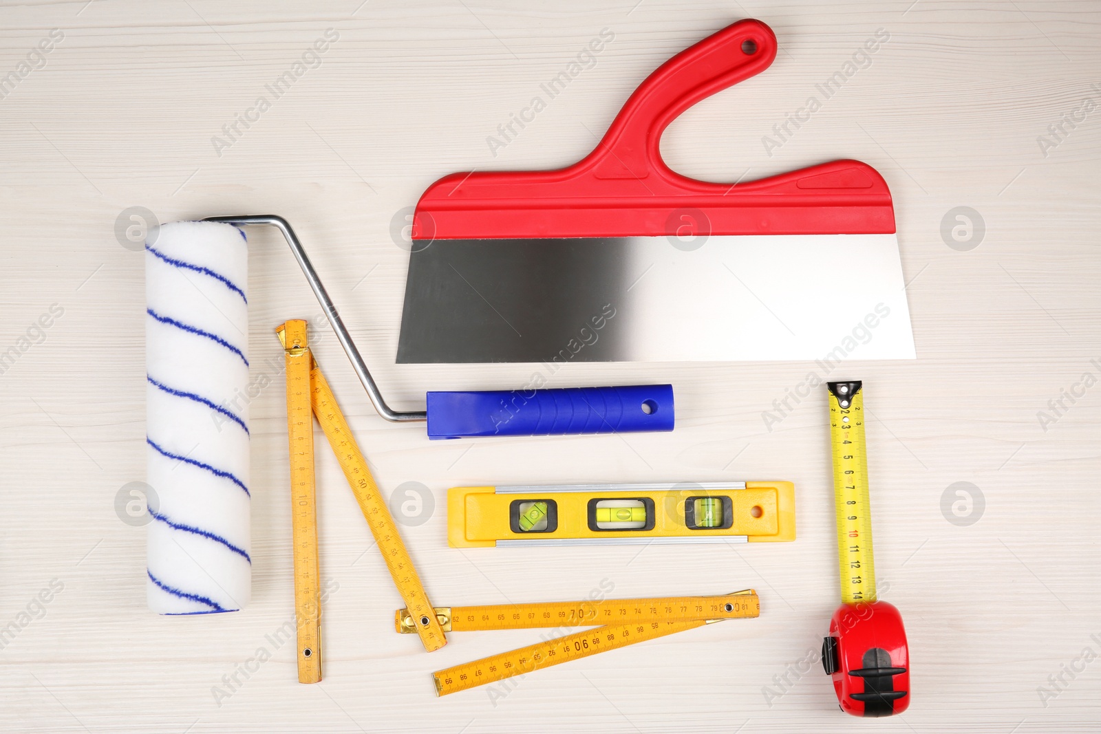 Photo of Different construction tools on light wooden table, flat lay