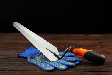 Putty knife and rubber glove on wooden table