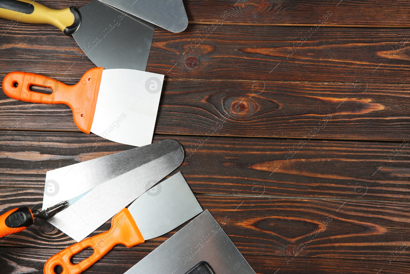 Photo of Putty knives on wooden table, flat lay. Space for text