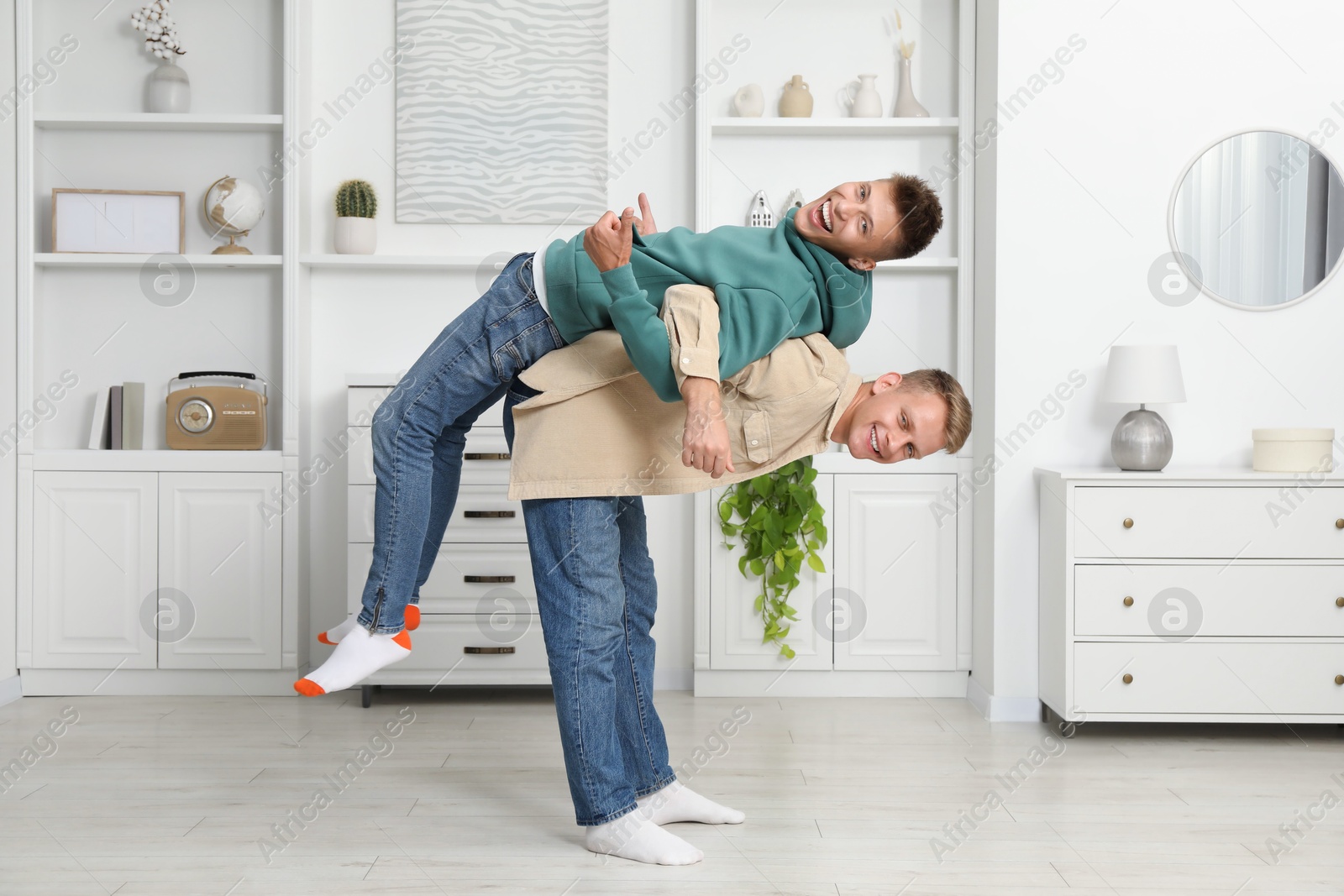 Photo of Full length portrait of happy brothers having fun at home