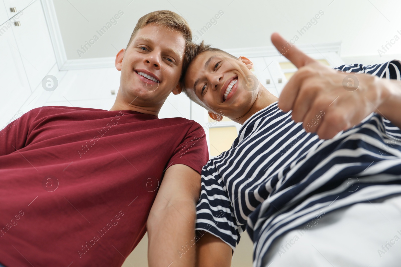 Photo of Family portrait of young brothers in kitchen, low angle view