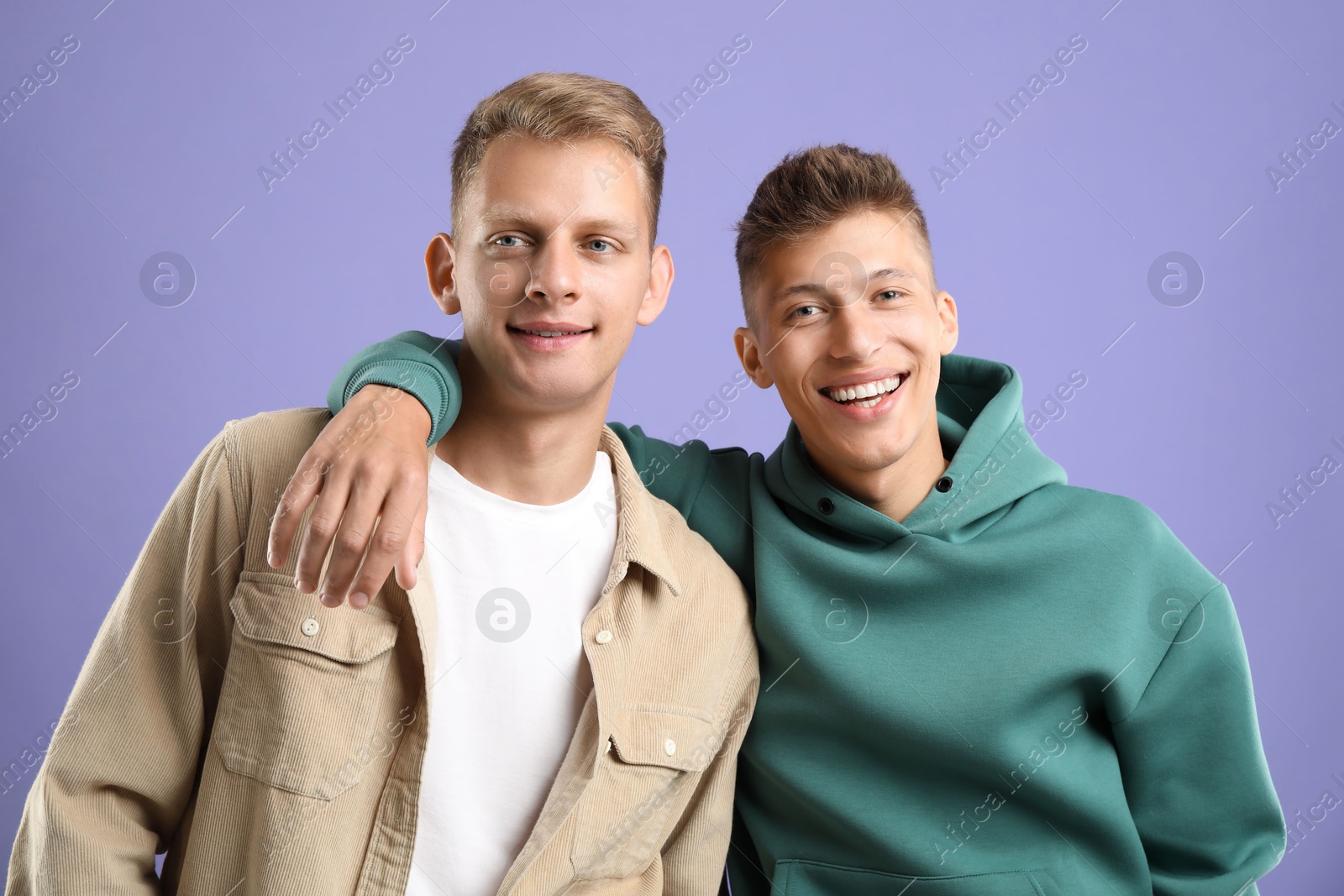 Photo of Portrait of happy brothers on violet background