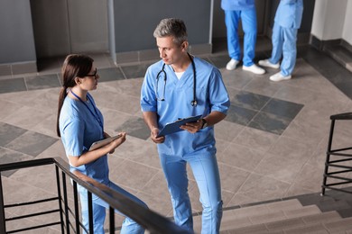 Healthcare workers talking on stairs in hospital