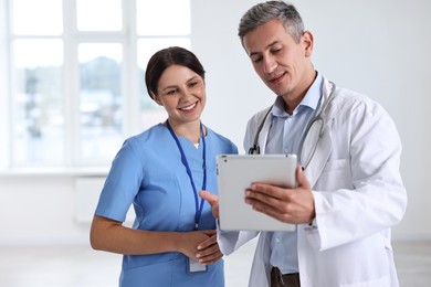 Photo of Smiling healthcare workers with tablet in hospital