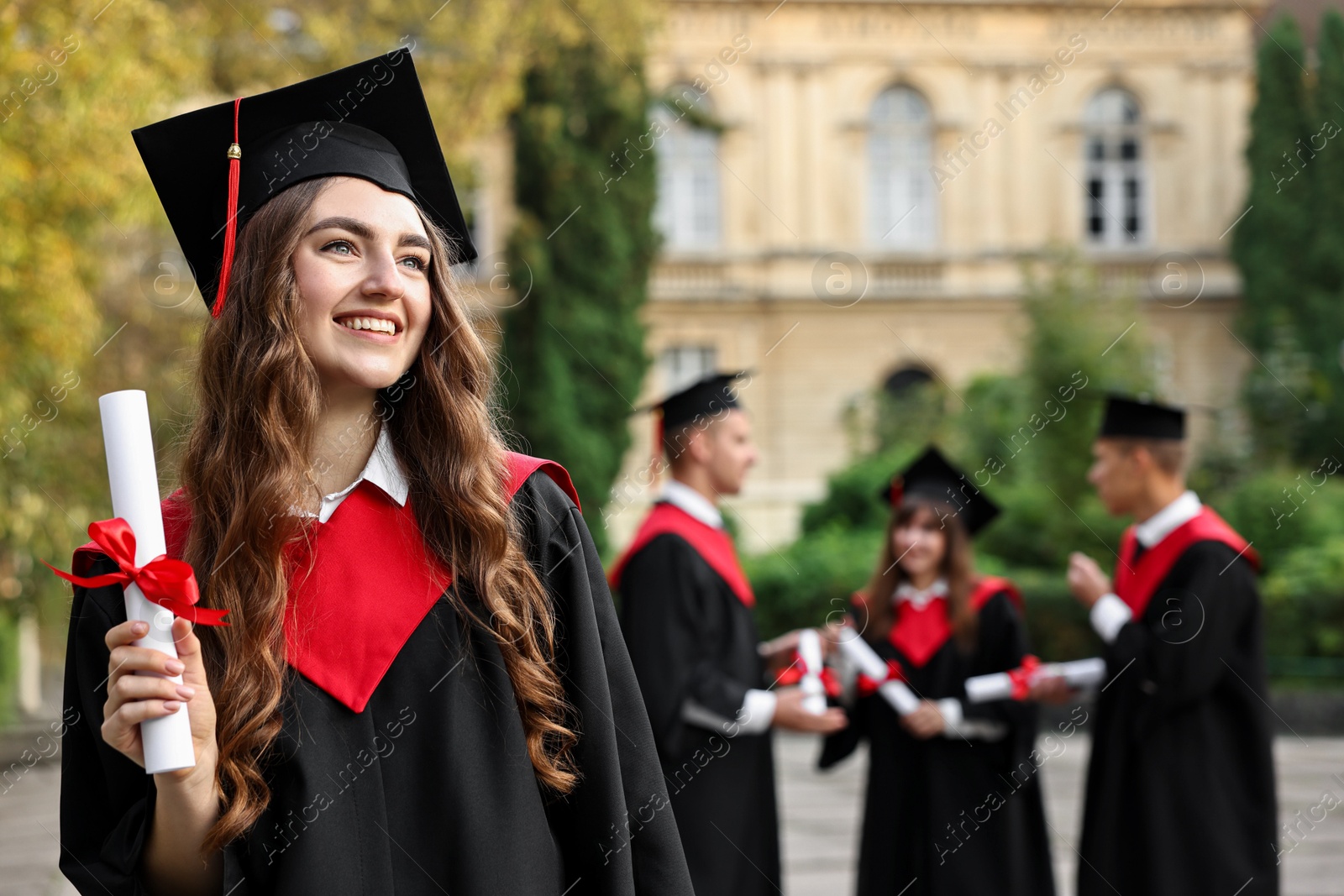 Photo of Happy students with diplomas after graduation ceremony outdoors, selective focus