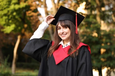 Photo of Graduation ceremony. Happy student in academic dress outdoors