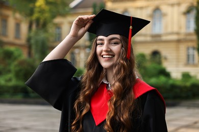 Graduation ceremony. Happy student in academic dress outdoors