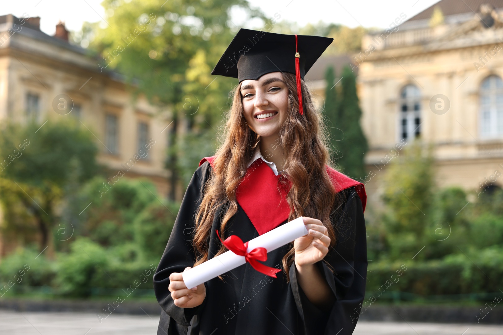 Photo of Happy student with diploma after graduation ceremony outdoors