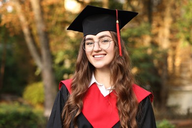 Photo of Graduation ceremony. Happy student in academic dress outdoors