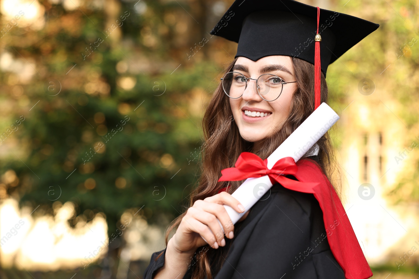 Photo of Happy student with diploma after graduation ceremony outdoors, space for text