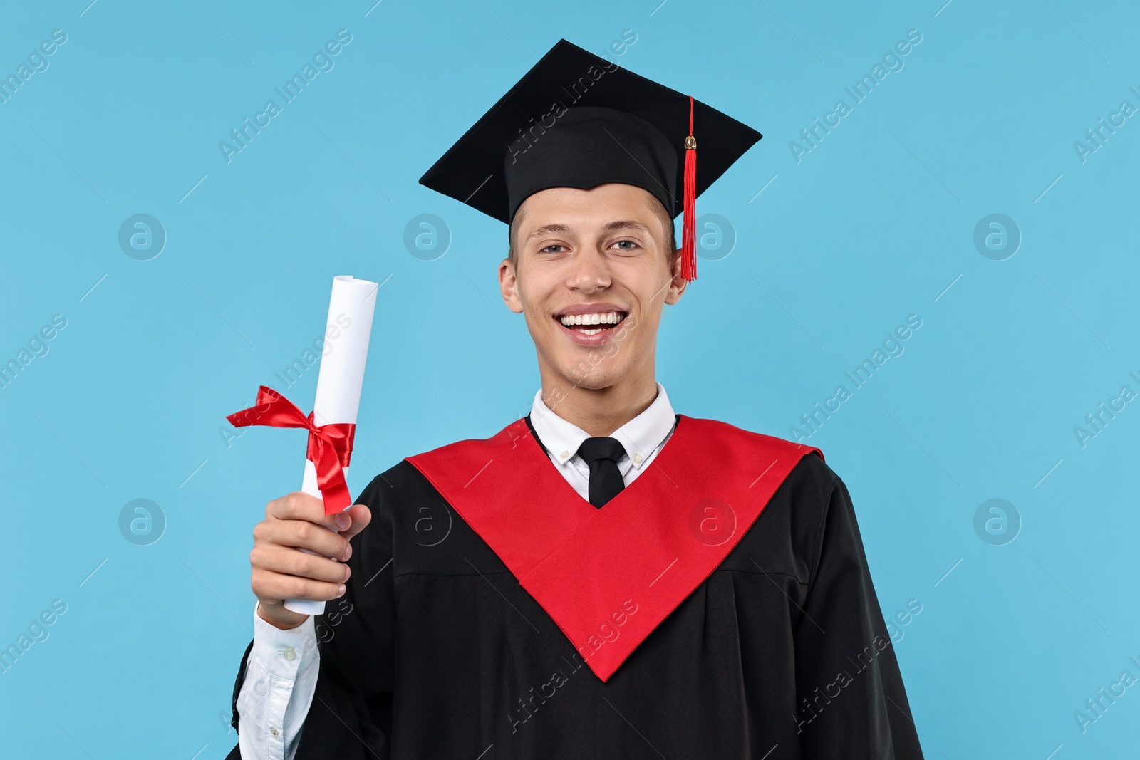 Photo of Happy student with diploma after graduation on light blue background